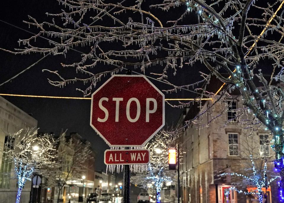 This stop sign and tree in downtown Adrian are both covered in ice Wednesday evening, Feb. 22, 2023, as a freezing rain and ice storm moved through Lenawee County and much of lower Michigan.