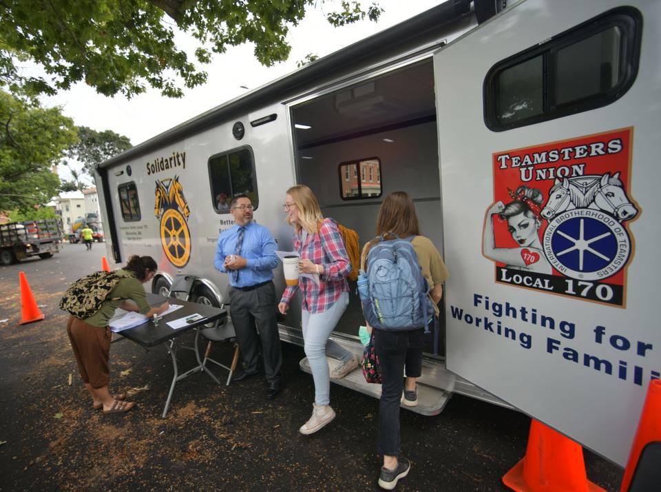 A student steps out of a trailer as another enters to vote on whether or not to authorize a strike Monday as part of the Clark University Graduate Workers Union. The trailer was provided by the Teamsters Local 170.