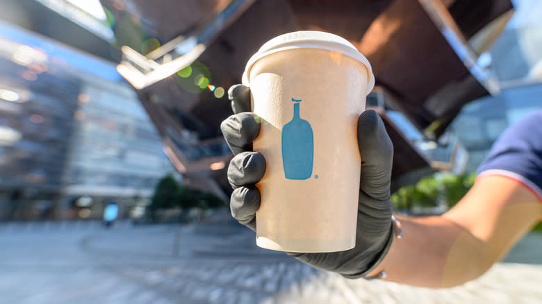 person holding Blue Bottle Coffee cup