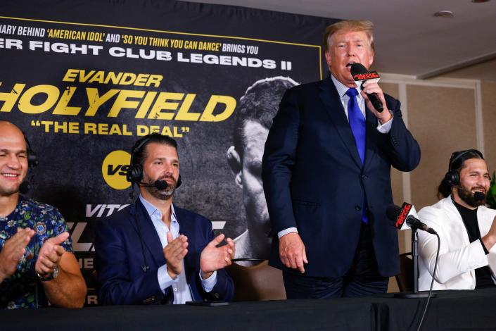 Former President Donald Trump and Donald Trump Jr. speak after the fight between Evander Holyfield and Vitor Belfort.