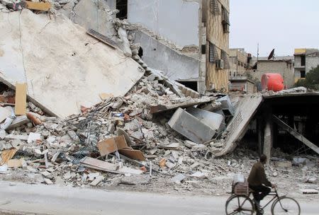 A man rides a bicycle past a damaged building in Daraya, near Damascus February 2, 2014.REUTERS/Omar Abu Bakr/Files