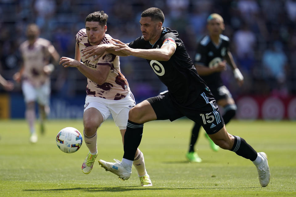 Portland Timbers defender Dario Zuparic (13) and Minnesota United defender Michael Boxall (15) battle for possession during the second half of an MLS soccer match at Allianz Field in Saint Paul, Minn., Saturday, July 30, 2022. (AP Photo/Abbie Parr)