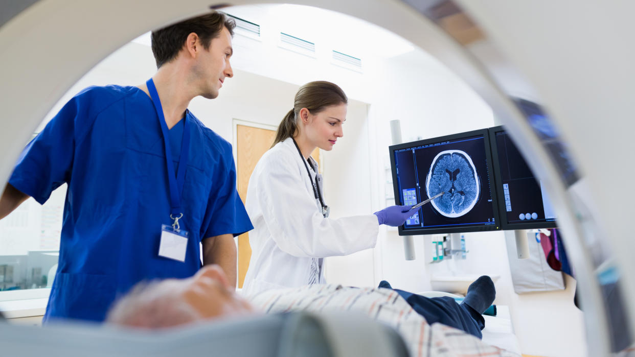 Two Doctors with Patient at CAT Scan.