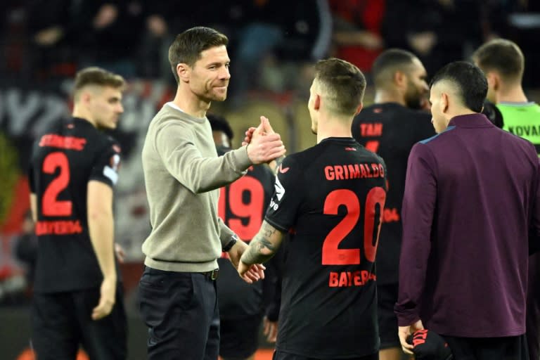 L'entraïneur du Bayer Leverkusen Xabi Alonso (à gauche) félicite ses joueurs à l'issue du match contre les anglais de West Ham à Leverkusen en Allemagne le 11 avril 2024 (INA FASSBENDER)