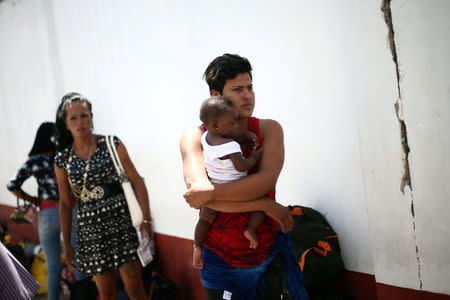 A Central American migrant, moving in a caravan through Mexico and traveling to request asylum in U.S, holds a baby as she arrives to Mexicali, Baja California state, Mexico April 25, 2018. REUTERS/Edgard Garrido