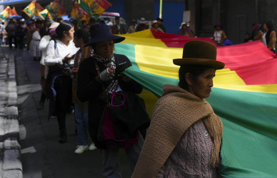 Women carry a Bolivian flag during an International Workers' Day march in La Paz, Bolivia, Wednesday, May 1, 2024. (AP Photo/Juan Karita)