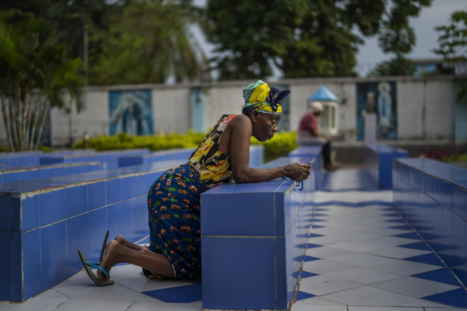 A woman prays outside the Cathedral Notre Dame du Congo in Kinshasa, Democratic Republic of the Congo Saturday Jan. 28, 2023. Pope Francis will be in Congo and South Sudan for a six-day trip starting Jan, 31, hoping to bring comfort and encouragement to two countries that have been riven by poverty, conflicts and what he calls a "colonialist mentality" that has exploited Africa for centuries. (AP Photo/Jerome Delay)