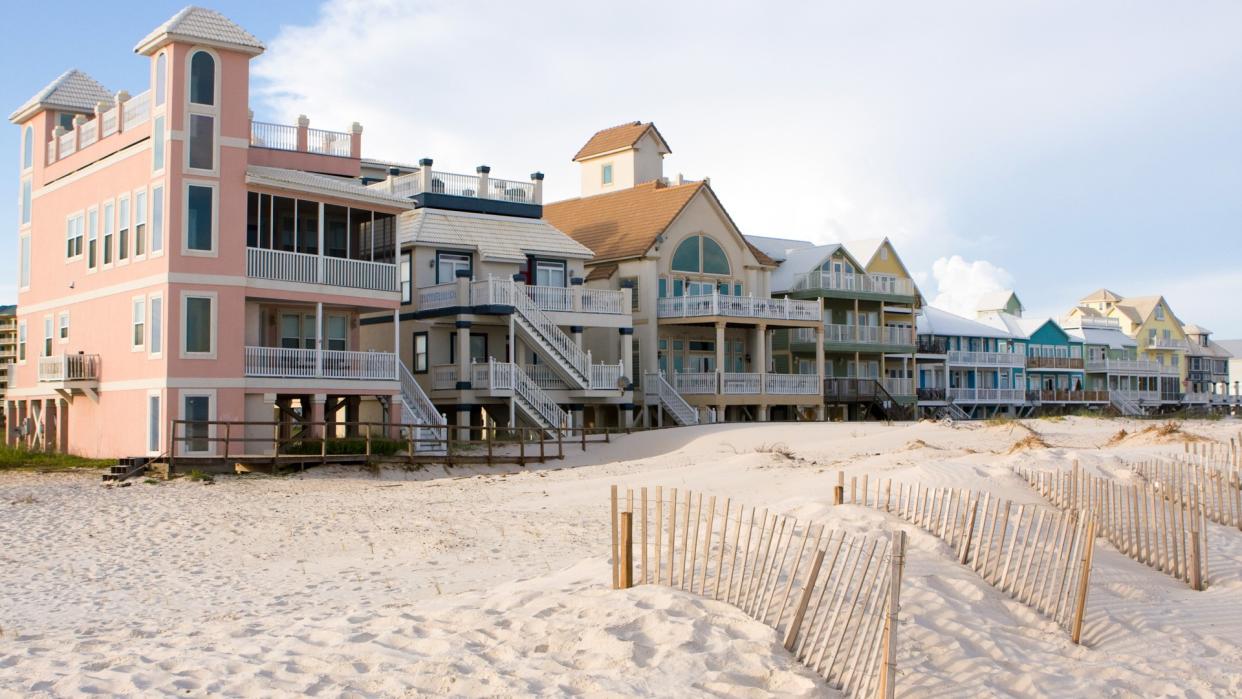 A row of luxury beach homes line the dunes along the Gulf Shores, Alabama coastline.