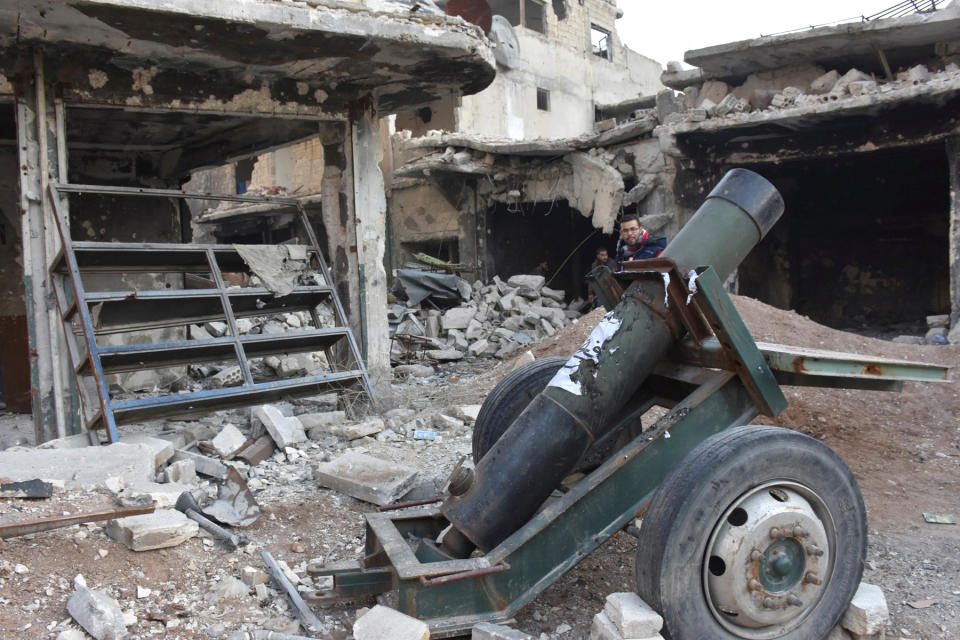 Syrian government soldiers walk near an abandoned weapon that belonged to rebels, after they took control of al-Sakhour neighborhood in Aleppo, Syria in this handout picture provided by SANA on November 28, 2016. SANA/Handout via REUTERS ATTENTION EDITORS - THIS IMAGE WAS PROVIDED BY A THIRD PARTY. EDITORIAL USE ONLY. REUTERS IS UNABLE TO INDEPENDENTLY VERIFY THIS IMAGE.