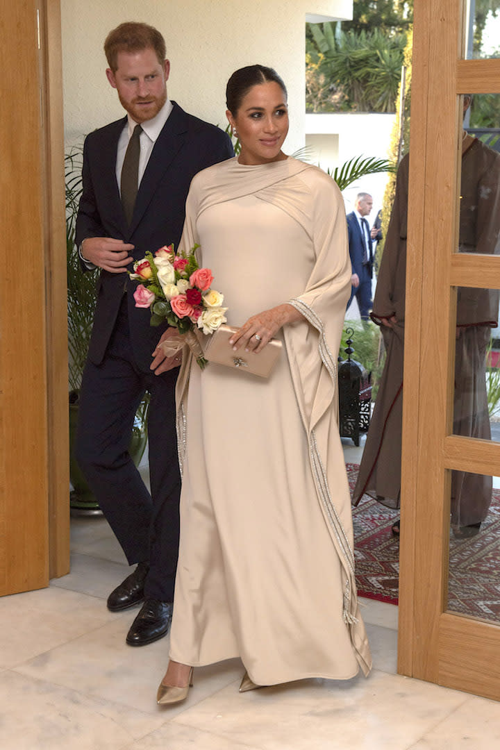 For a reception hosted by British Ambassador to Morocco, the Duchess of Sussex dressed her bump in a couture Dior dress with a matching metallic clutch and shoes. [Photo: Getty]