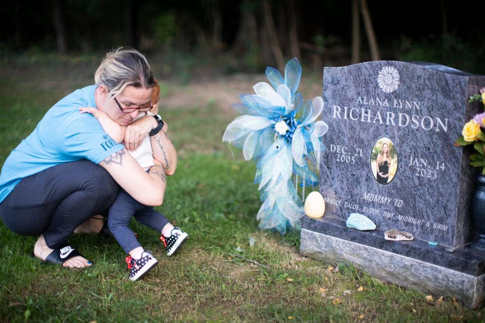 Roxanne Gillenwater hugs her 1-year-old granddaughter, Brielle, whom she cares for, at the gravesite of her daughter, Alana Richardson, who died in January 2023 at age 17 while in custody at the Central Ohio Youth Center in Marysville.