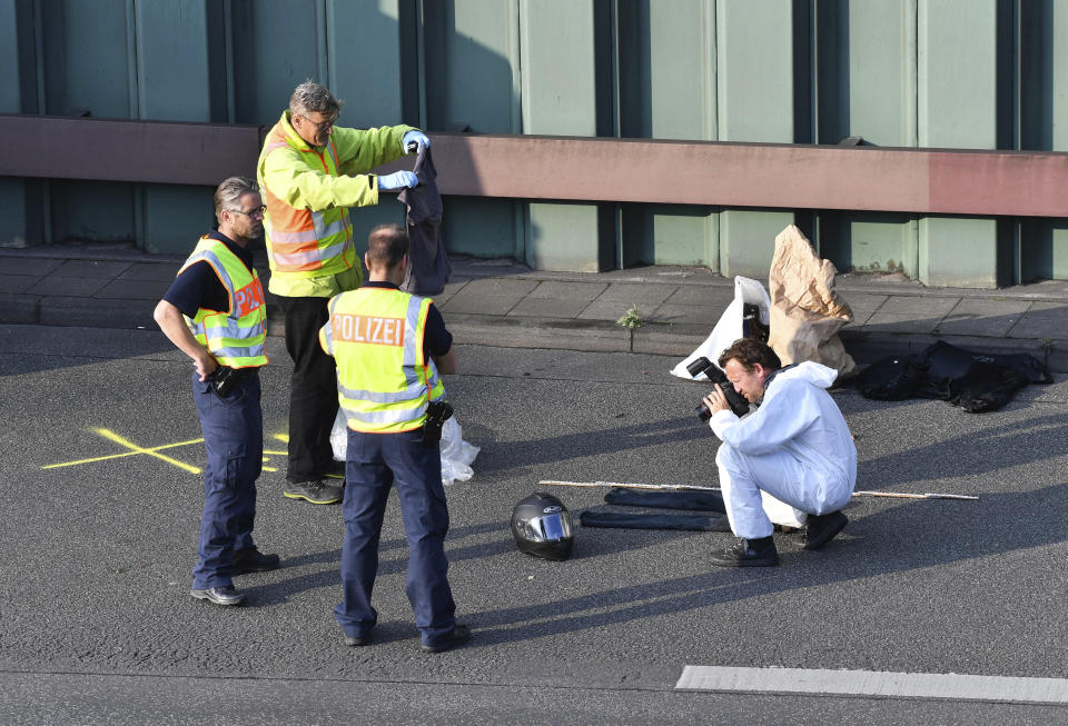 Police officers investigate on the scene following several accidents on the city motorway A100 in Berlin, Germany, Wednesday, Aug. 19, 2020. According to German news agency dpa, prosecutors say a series of crashes caused by a 30-year-old Iraqi man on the highway late Tuesday night was an Islamic extremist attack. (Paul Zinken/dpa via AP)