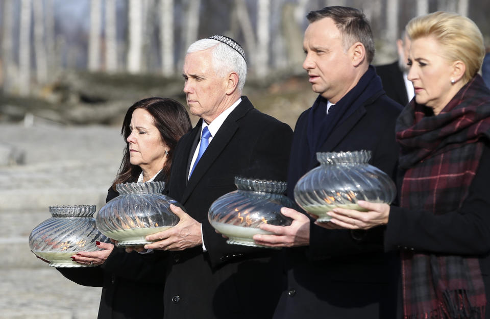 United States Vice President Mike Pence and his wife Karen Pence, left, walk with Poland's President Andrzej Duda and his wife Agata Kornhauser-Duda, right, with lights in their hands during their visit at the Nazi concentration camp Auschwitz-Birkenau in Oswiecim, Poland, Friday, Feb. 15, 2019. (AP Photo/Michael Sohn)