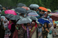 Women stand under umbrellas as they watch the body of Zakir Rashid Bhat also known as Zakir Musa, the leader of an al Qaeda affiliated militant group in Kashmir, during his funeral procession in Dadasara village in south Kashmir's Tral May 24, 2019. REUTERS/Danish Ismail