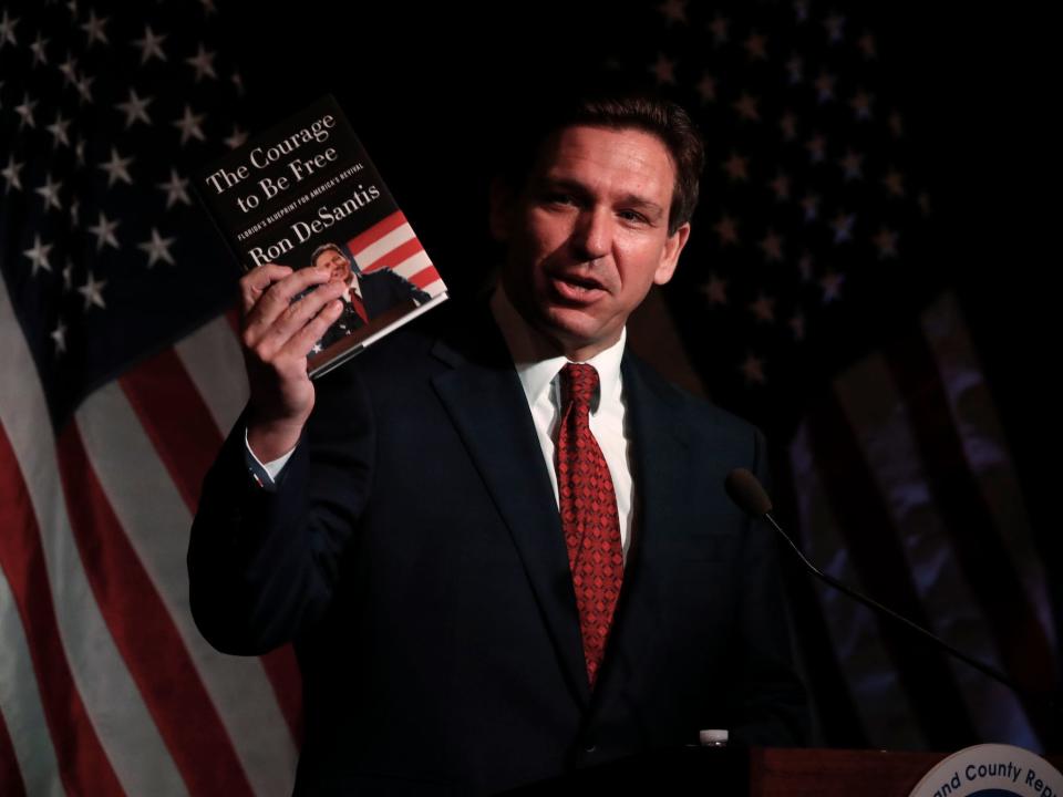 Florida Gov. Ron DeSantis holds his book while speaking at the Midland County Republican Party Dave Camp Spring Breakfast on April 6, 2023 in Midland, Michigan. While in Michigan, DeSantis will also visit Hillsdale College, a small, Christian liberal arts school.