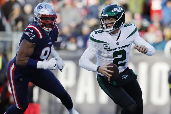 New York Jets quarterback Zach Wilson (2) runs as New England Patriots defensive end Deatrich Wise Jr. (91) gives chase during the second half of an NFL football game, Sunday, Nov. 20, 2022, in Foxborough, Mass. (AP Photo/Michael Dwyer)