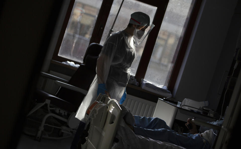 A medic from the Belgian Army tends to a patient with COVID-19 at the St. Michiel Hospital in Brussels, Tuesday, Nov. 24, 2020. The Belgian military has been called into several hospitals and care homes to alleviate the stress on healthcare personnel. (AP Photo/Virginia Mayo)