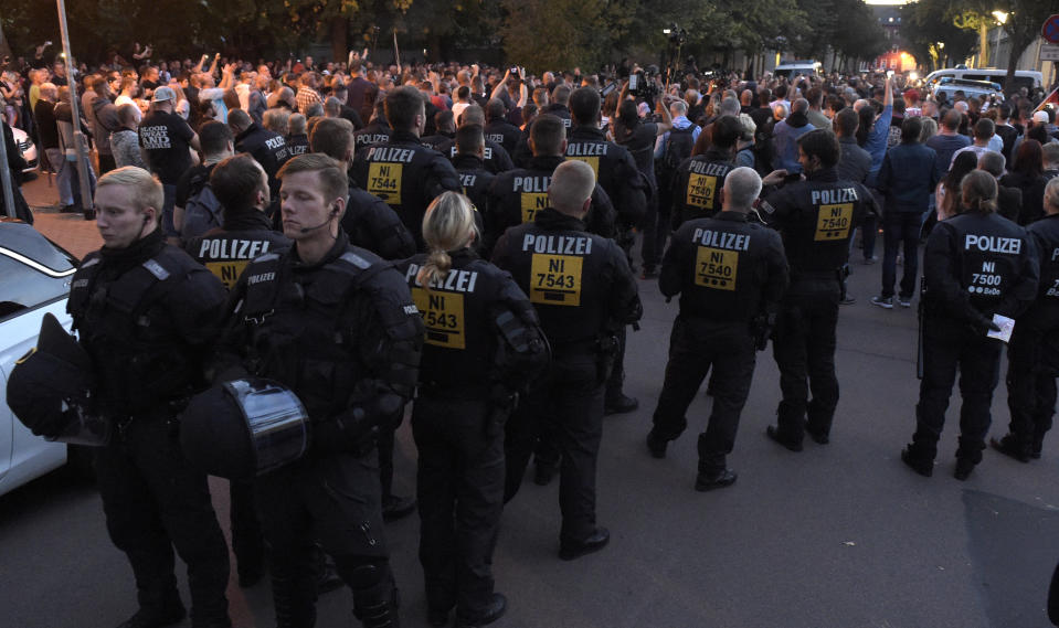 Police secure a demonstration in Koethen, 90 miles southwest of the German capital Berlin, Sunday, Sept. 9, 2018, after police has arrested two Afghan men after a 22-year-old German man died after brawl. (AP Photo/Jens Meyer)