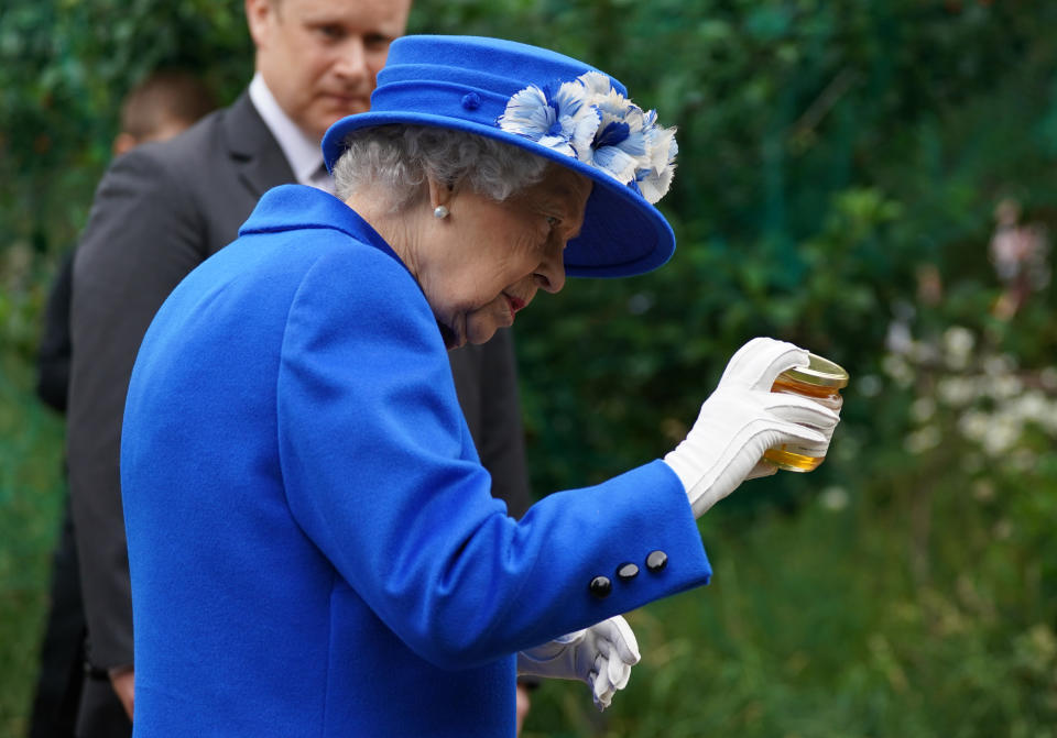 <p>Queen Elizabeth II is given a jar of honey during a visit to a community project in Glasgow, as part of her traditional trip to Scotland for Holyrood Week. Picture date: Wednesday June 30, 2021.</p>
