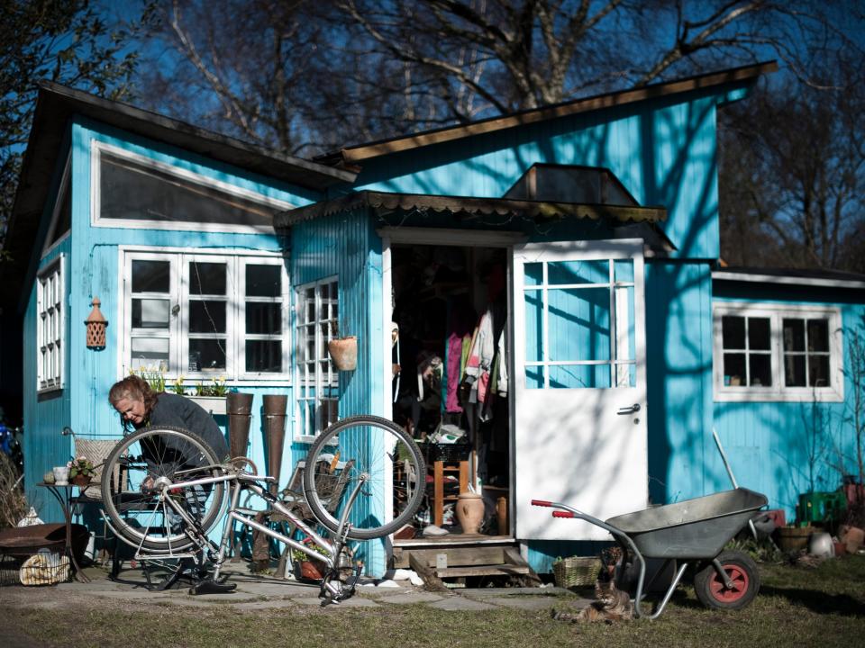 A woman repairs her bike outside her house in Christiania in 2012.