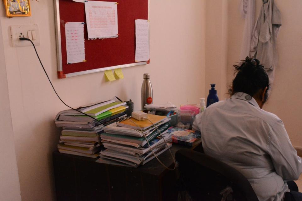 Books for entrance exam preparation stacked on study table of a student in their hostel (Namita Singh/The Independent)