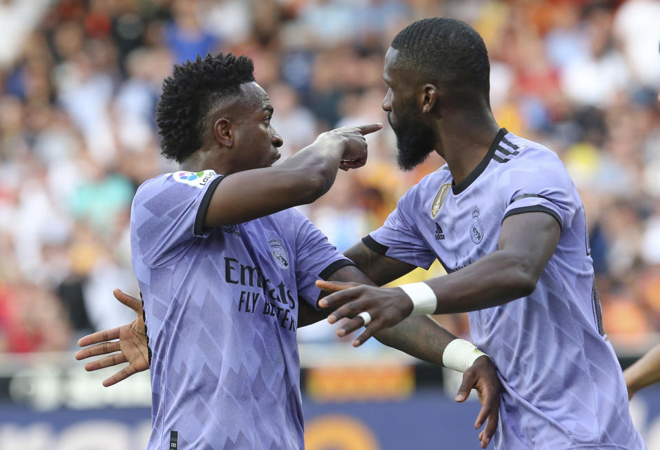 Real Madrid's Vinicius Junior, left, confronts Valencia fans as Antonio Rudiger tries to calm him down during a Spanish La Liga soccer match between Valencia and Real Madrid, at the Mestalla stadium in Valencia, Spain, Sunday, May 21, 2023. The game was temporarily stopped when Vinicius said a fan had insulted him from the stands. He was later sent off after clashing with Valencia players. (AP Photo/Alberto Saiz)