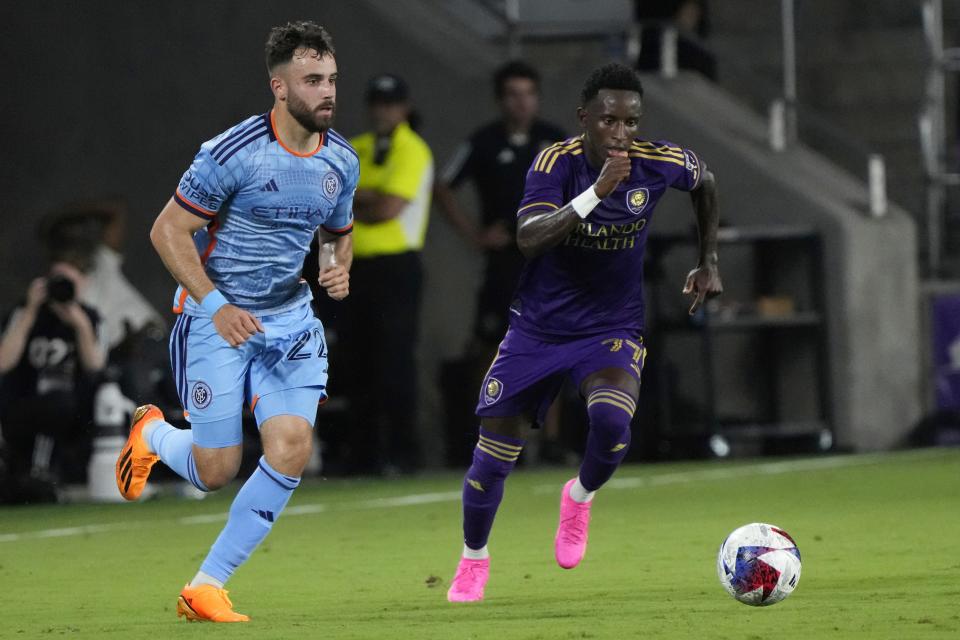 New York City FC's Kevin O'Toole, left, moves the ball past Orlando City's Ivan Angulo during the second half of an MLS soccer match Wednesday, May 17, 2023, in Orlando, Fla. (AP Photo/John Raoux)