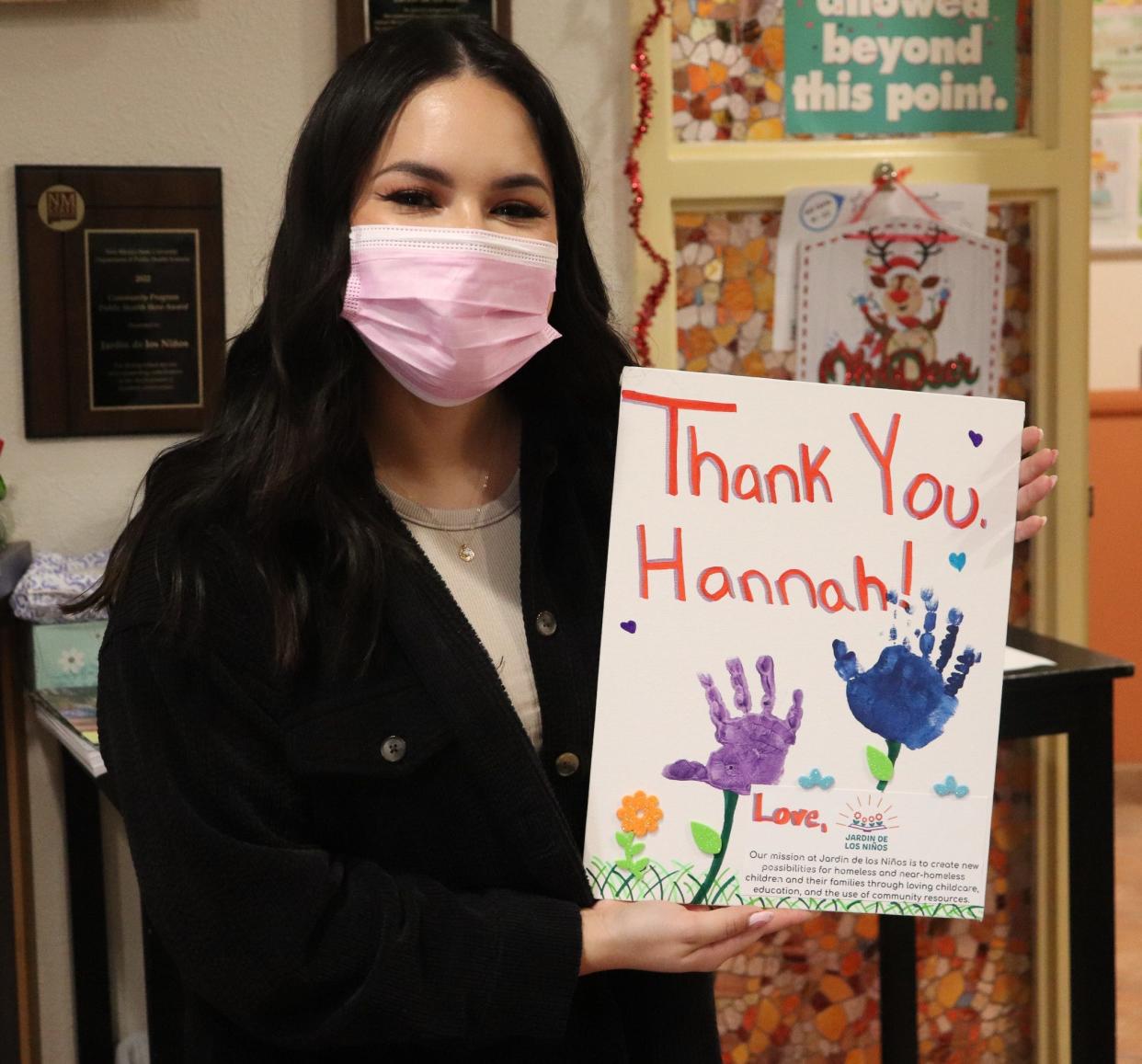 Hannah Martinez poses with a handmade card from Jardin de los Niõs thanking her for all her donations.