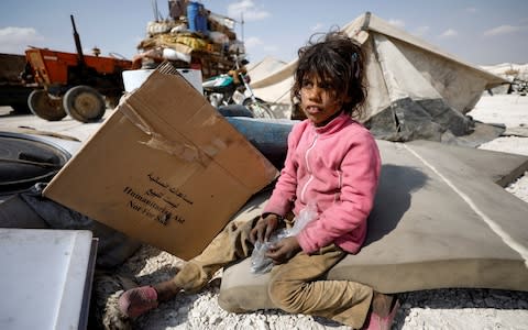 An internally displaced girl who fled Raqqa city sits inside a camp in Ain Issa, Raqqa Governorate,  - Credit: Reuters