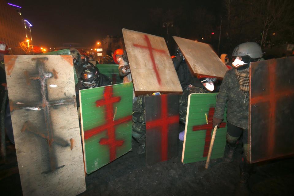 FILE In this file photo taken on Tuesday, Jan. 21, 2014, protesters clad in improvised protective gear prepare for a clash with police in central Kiev, Ukraine. After a night of vicious street battles, anti-government protesters and police clashed again Monday in Ukraine's capital. Hundreds of protesters, many wearing balaclavas, hurled rocks and stun grenades. Police responded with tear gas. (AP Photo/Sergei Grits, file)