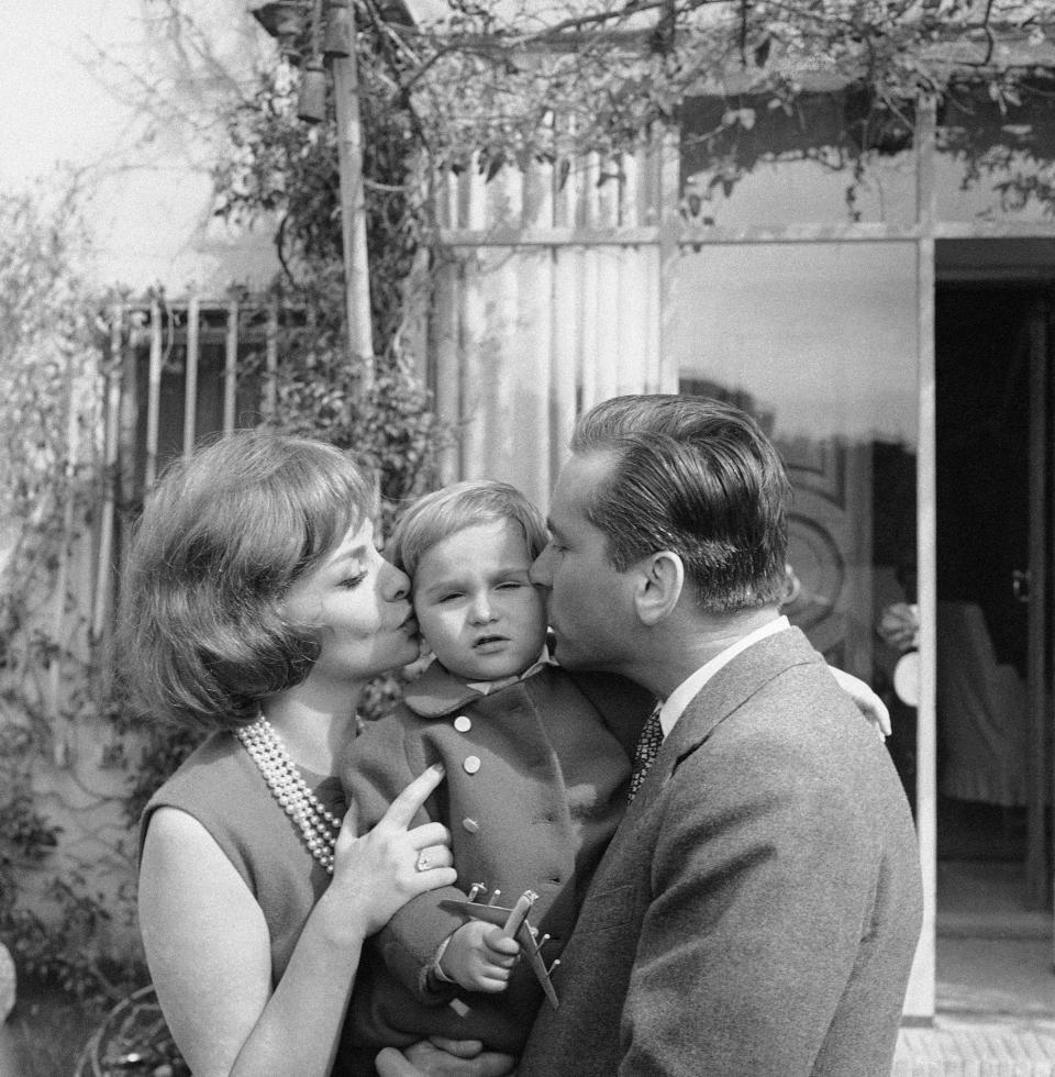 FILE - Actress Gina Lollobrigida and her husband, Dr. Milko Skofic, kiss their two-year-old son, Milko, Jr., on the couple's arrival in Rome, March 17, 1960. Lollobrigida has died in Rome at age 95. Italian news agency Lapresse reported Lollobrigida’s death on Monday, Jan. 16, 2023 quoting Tuscany Gov. Eugenio Giani. (AP Photo/Jim Pringle, File)