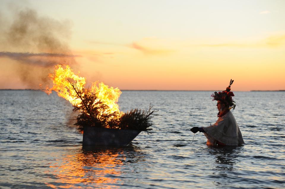 Jay Critchley, CEO of the Re-Rooters Day Society, lights the tree-boat on fire and sets it free at the 2021 Re-Rooters Day Ceremony in Provincetown. People were last year asked to email messages, discards and rants to purge 2020 to burn on the boat.