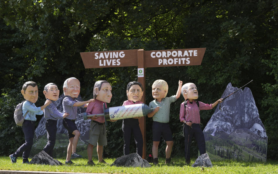 Activists from Oxfam wear giant heads of G7 leaders as they pose with a giant syringe during a demonstration in Munich, Germany, Saturday, June 25, 2022. The G7 Summit will take place at Castle Elmau near Garmisch-Partenkirchen from June 26 through June 28, 2022. Leaders depicted from left, French President Emmanuel Macron, Japan's Prime Minister Fumio Kishida, U.S. President Joe Biden, Italy's Prime Minister Mario Draghi, Canada's Prime Minister Justin Trudeau, British Prime Minister Boris Johnson and German Chancellor Olaf Scholz. (AP Photo/Matthias Schrader)