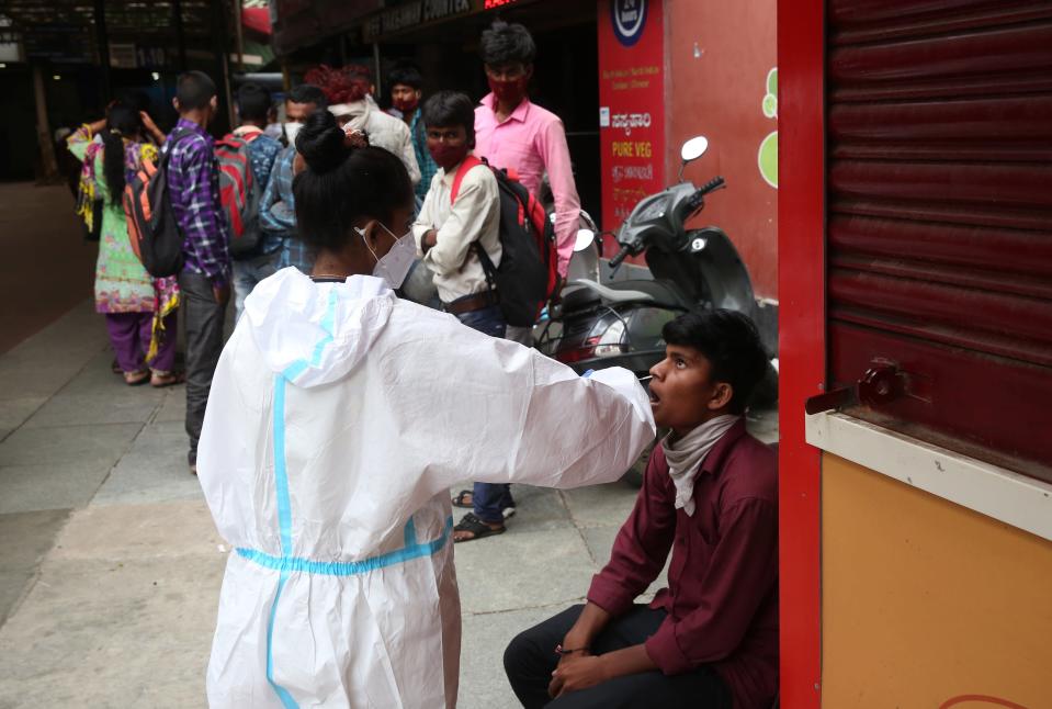 A health worker takes a swab and nasal sample of a man for Covid-19 test at a city railway station in Bengaluru, India, on 14 June 2021.  (EPA)