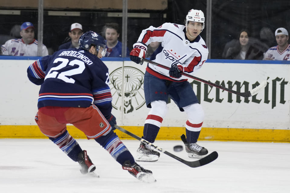 Washington Capitals' Dylan Strome, right, passes around New York Rangers' Jonny Brodzinski (22) during the first period of an NHL hockey game, Sunday, Jan. 14, 2024, in New York. (AP Photo/Seth Wenig)