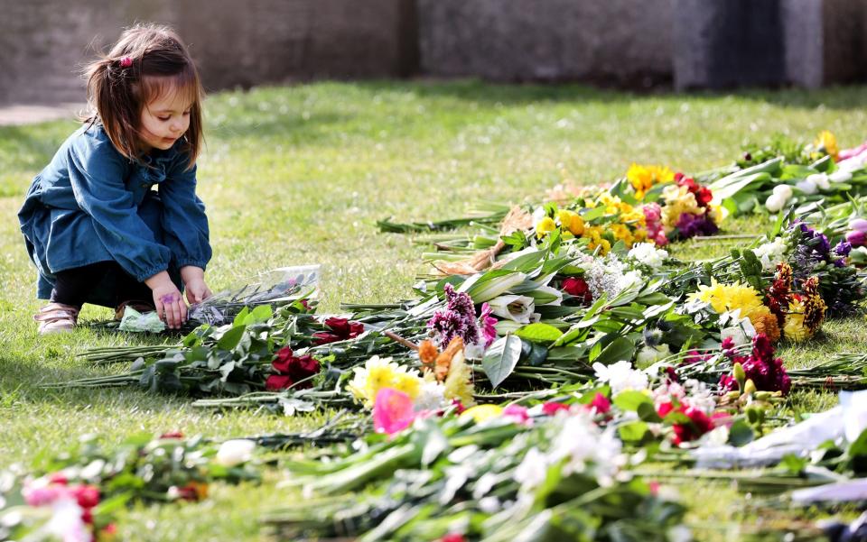 A child lays flowers outside Windsor Castle on April 9 - Chris Jackson 