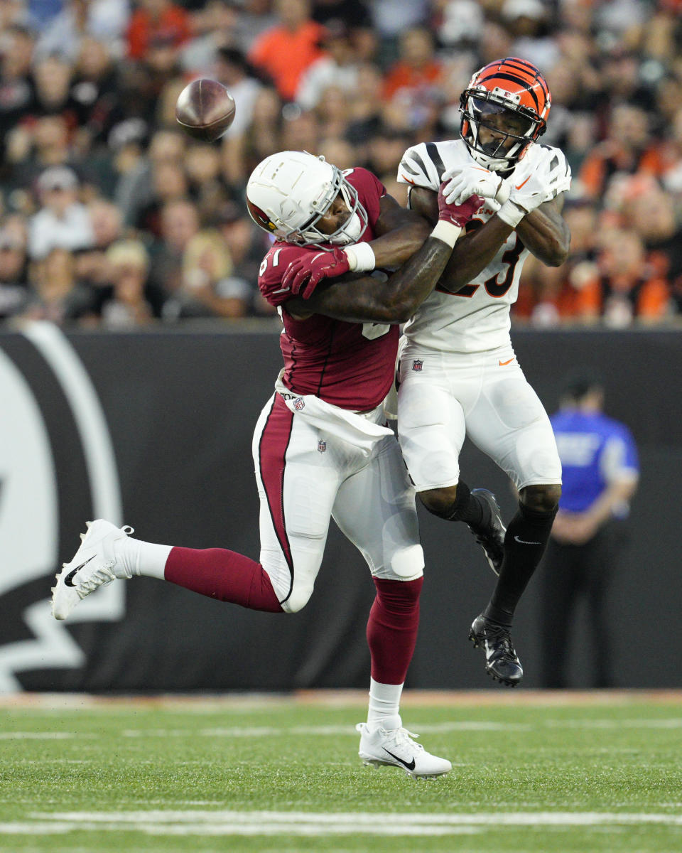 Arizona Cardinals tight end Deon Yelder, left, and Cincinnati Bengals safety Dax Hill both fail to come down with a pass during the second quarter of an NFL football preseason game in Cincinnati, Friday, Aug. 12, 2022. (AP Photo/Jeff Dean)