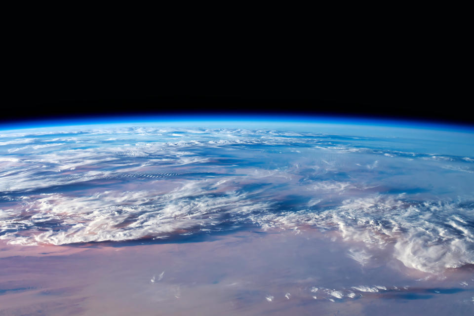 Earth's curved horizon with clouds and land from space