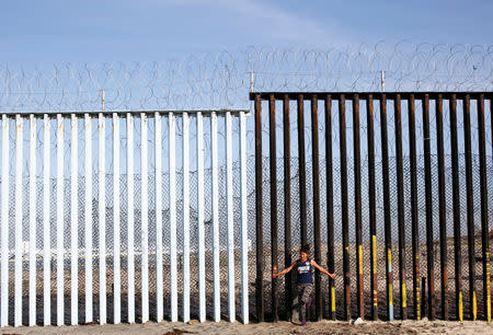 Damaris Alejandra Tejeda, 15, a migrant from Honduras, part of a caravan of thousands traveling from Central America en route to the United States, poses in front of the border wall between the U.S. and Mexico in Tijuana, Mexico, November 23, 2018. Tejeda said she was wearing combat trousers and a sports t-shirt because that is how she imagined from films and the news media that Americans dress. "My dream is to have the opportunity there of studying and working," said Tejeda, who had to leave school early to help provide for her family. REUTERS/Kim Kyung-Hoon