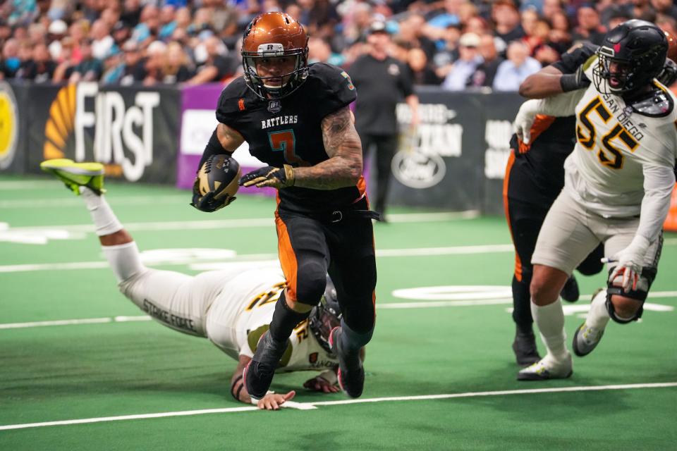 Rattlers running back Shannon Brooks (3), center, skips past a challenge to score a touchdown during the second half against the San Diego Strike Force at the Footprint Center on Friday, April 15, 2022, in Phoenix. The Rattlers won the game 66-33.