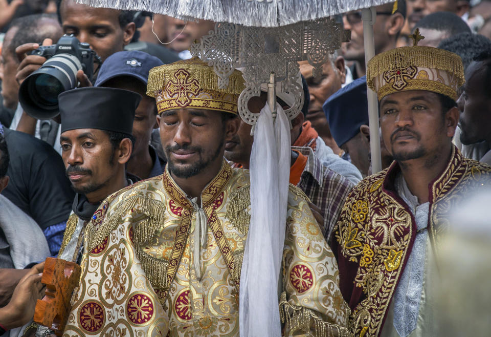 A priest cries at a mass funeral at the Holy Trinity Cathedral in Addis Ababa, Ethiopia Sunday, March 17, 2019. Thousands of Ethiopians have turned out to a mass funeral ceremony in the capital one week after the Ethiopian Airlines plane crash. Officials have begun delivering bags of earth to family members of the 157 victims of the crash instead of the remains of their loved ones because the identification process is going to take such a long time. (AP Photo/Mulugeta Ayene)