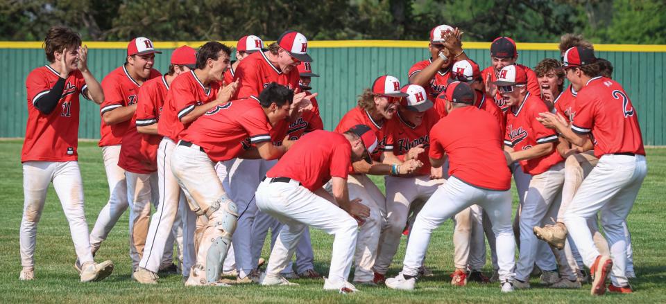 New Boston Huron celebrates after surviving a 10-inning battle with Airport in the finals of the Division 2 District at Airport to win 4-1 Saturday.