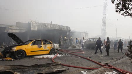 People gather at the site of a car bomb attack in Baghdad al-Jadida, Iraq April 25, 2016. REUTERS/Khalid al Mousily