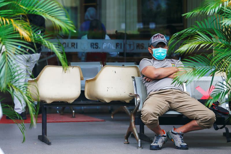 A man wearing a protective face mask sits on a chair while maintaining social distance amid the coronavirus disease (COVID-19) pandemic in Jakarta