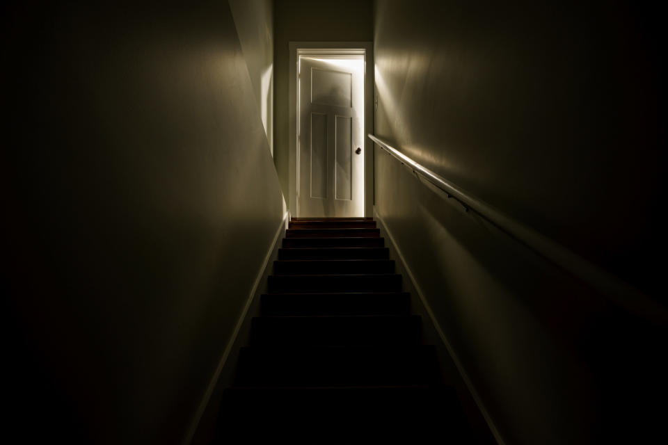 An opened door at the top of a flight of stairs