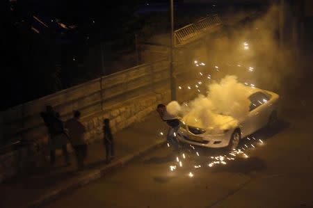 A Palestinian protester runs for cover from a stun grenade fired by Israeli police during clashes in the east Jerusalem neighbourhood of Silwan October 26, 2014. REUTERS/Ammar Awad