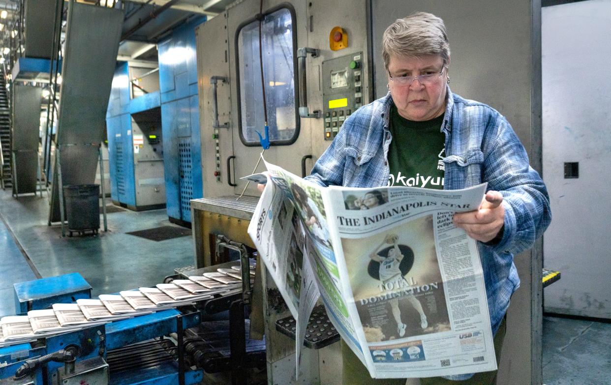 Before leaving for the night, Cindy Norman picks up an Indianapolis Star, Sunday, April 7, 2024 at the Pulliam Production Center. Norman has been on the presses for just over 34 years.