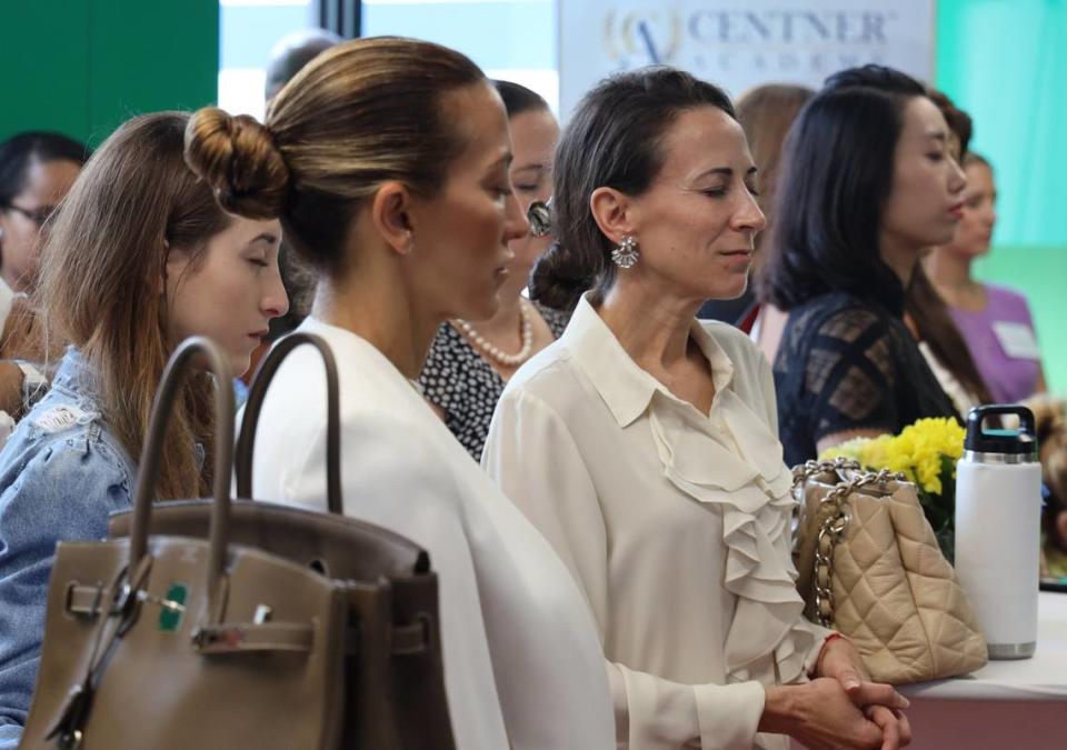 Guests close their eyes during a moment of meditation at the Centner Academy’s ribbon-cutting on Aug. 21, 2019.