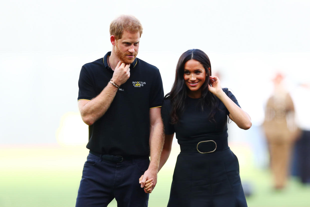 Harry and Meghan, pictured at a baseball match, choose different Instagram accounts to follow each month. [Photo: Getty]