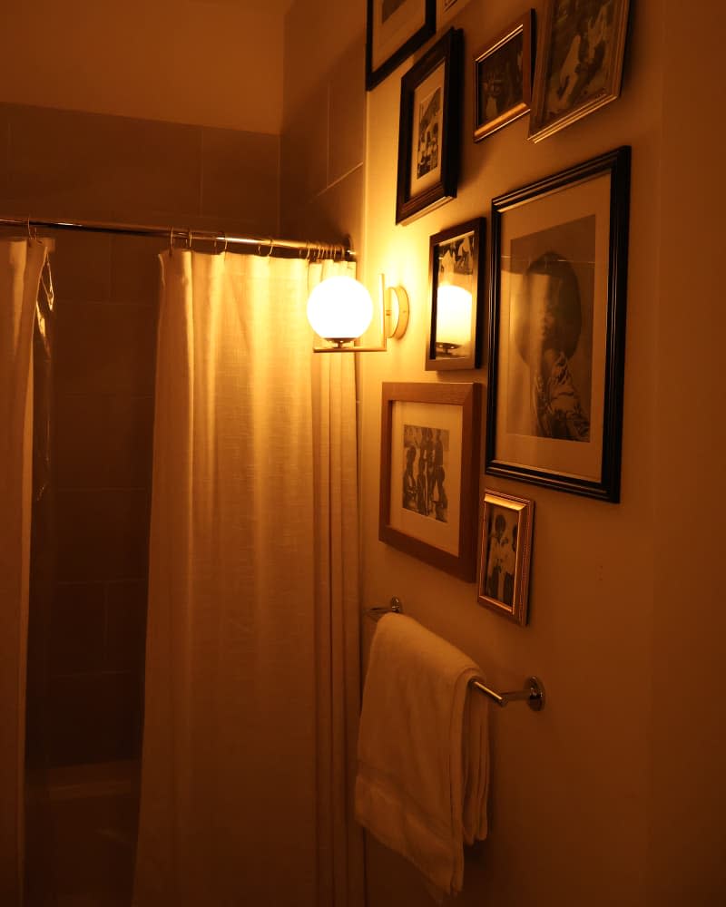 bathroom lit by warm light sconce after makeover